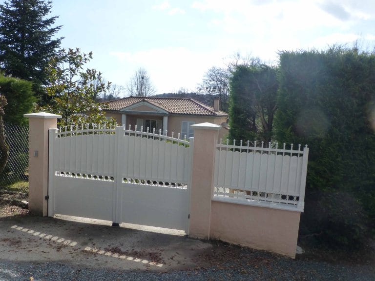 Clôture ajourée en aluminium blanc à barreaux posée sur muret, à côté du portail assorti, à Pommiers