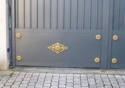 Zoom détail ornements couleur or marguerites sur les 4 coins et rosace centrale portail aluminium style classique posé en rénovation à Anse (69480)