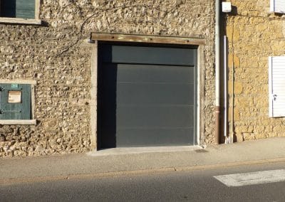 Vue côté rue porte de garage sectionnelle posée en rénovation à Liergues