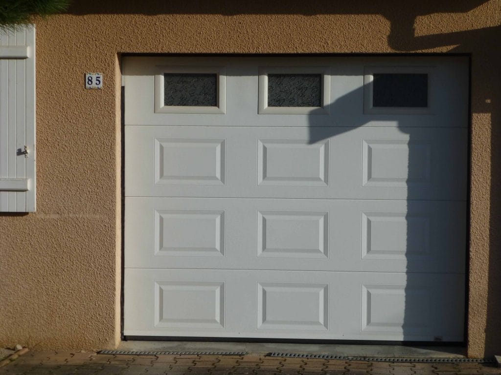 Porte de garage sectionnelle blanche à panneaux et hublots posée par La Clé Beaujolaise à Liergues