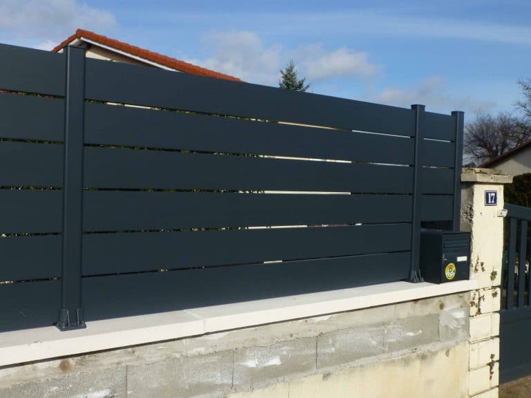 Clôture semi-ajourée en aluminium à lames espacées posée sur muret, en rénovation à Limas