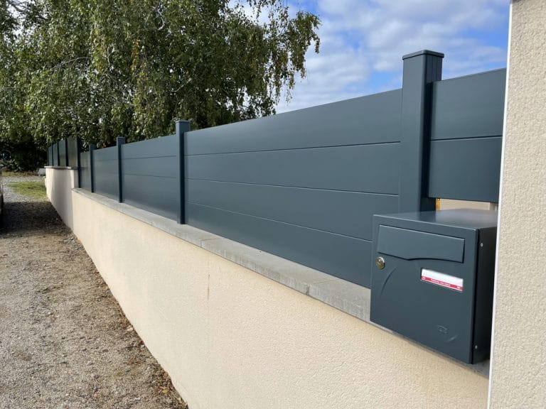 Clôture en aluminium à lames posée sur un muret existant, avec boîte aux lettres intégrée aux normes de La Poste, à Pommiers